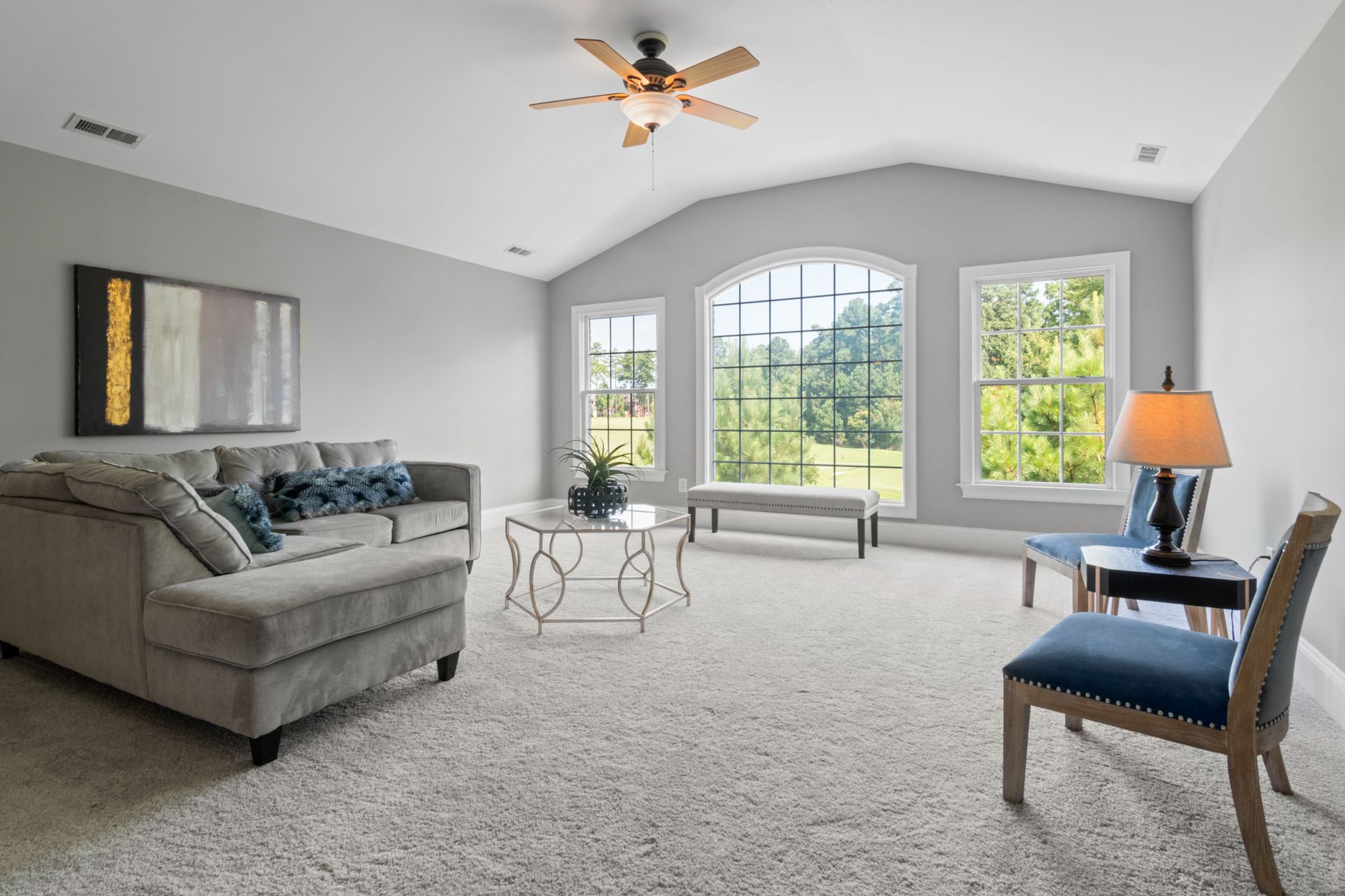 Neutral living room with large windows and uncluttered furniture