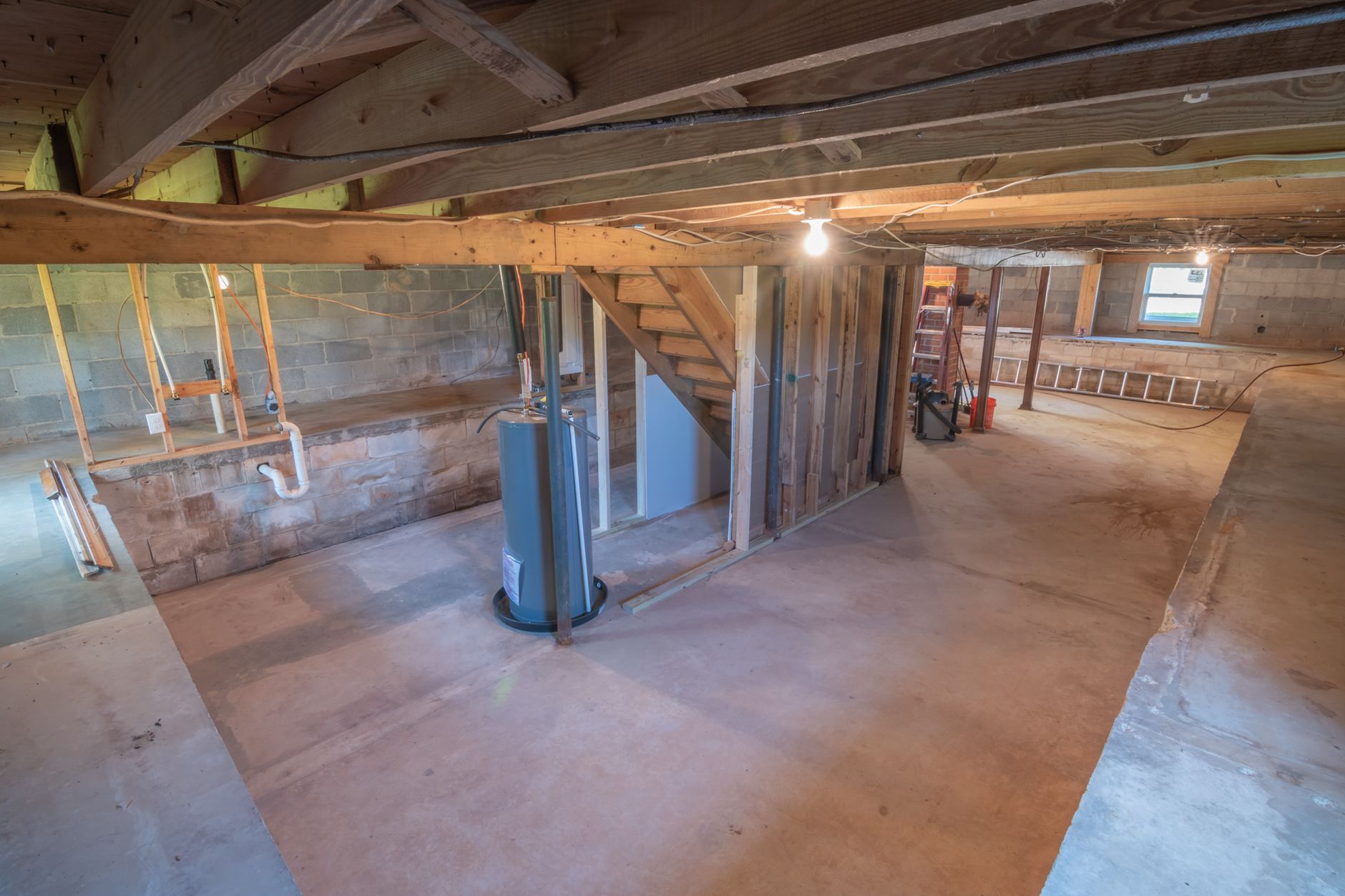 Unfinished basement showing exposed beams and plumbing