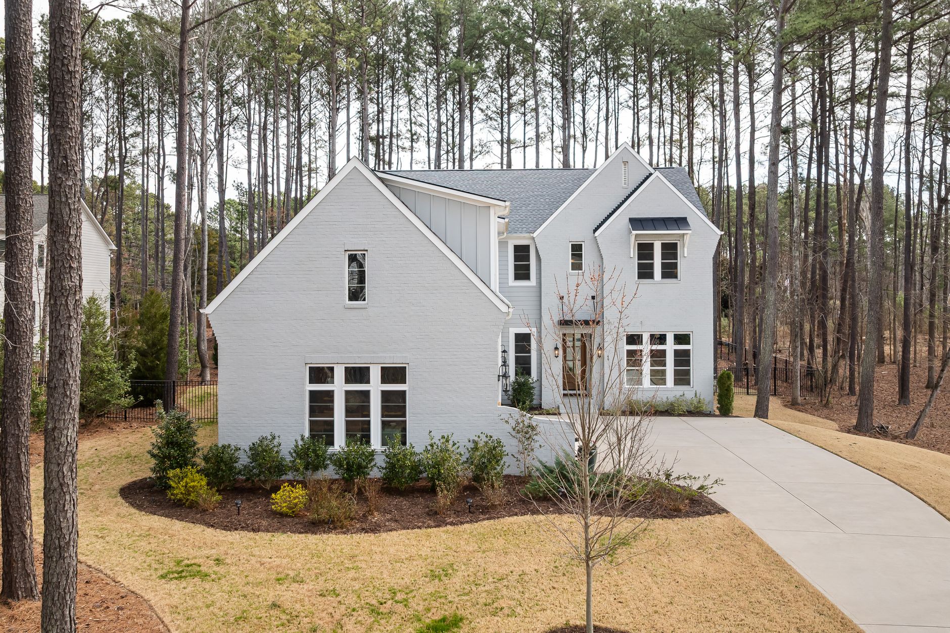 White residence framed by mature pine trees