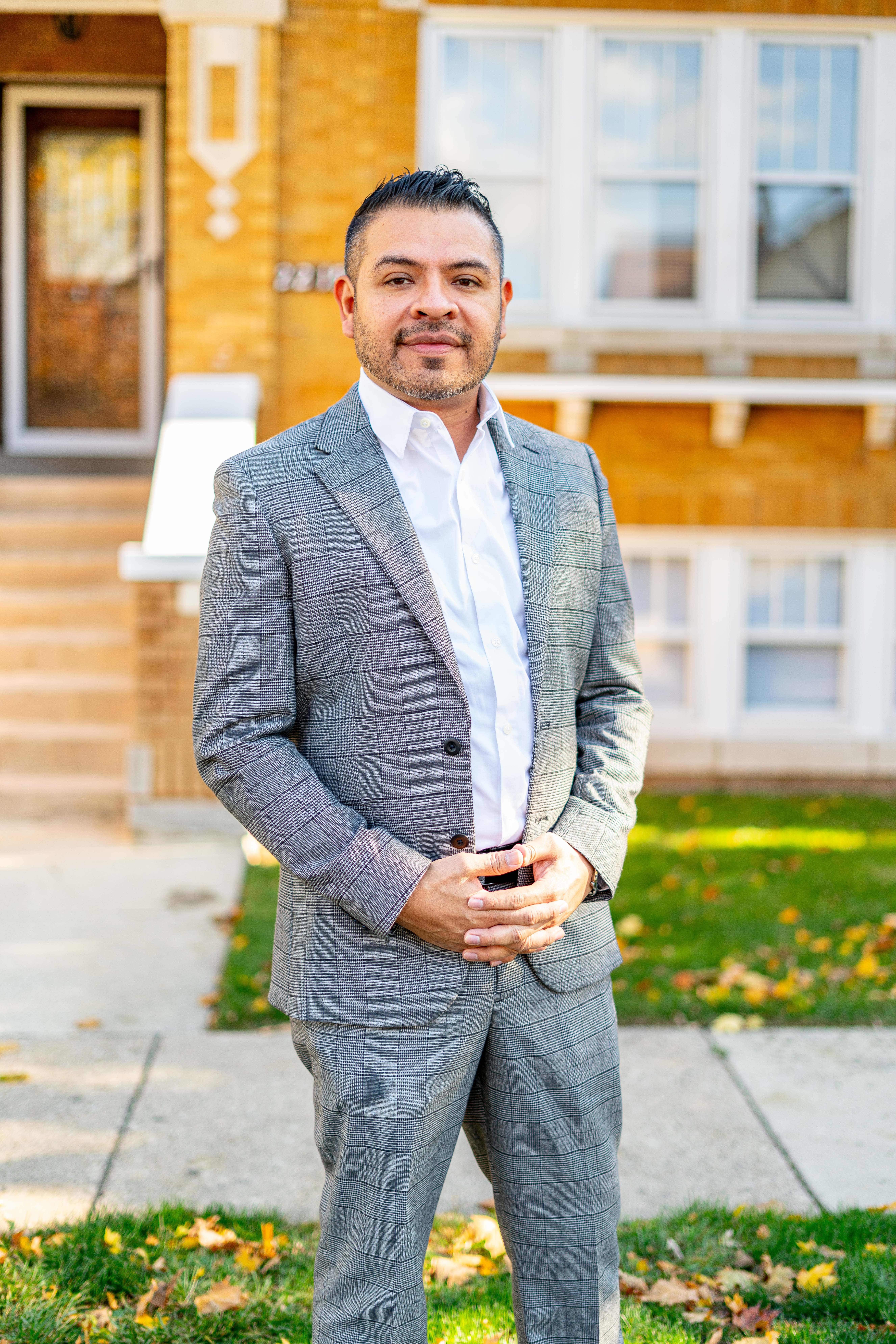 Jose Contreras outdoors in a gray suit in front of a brick residence