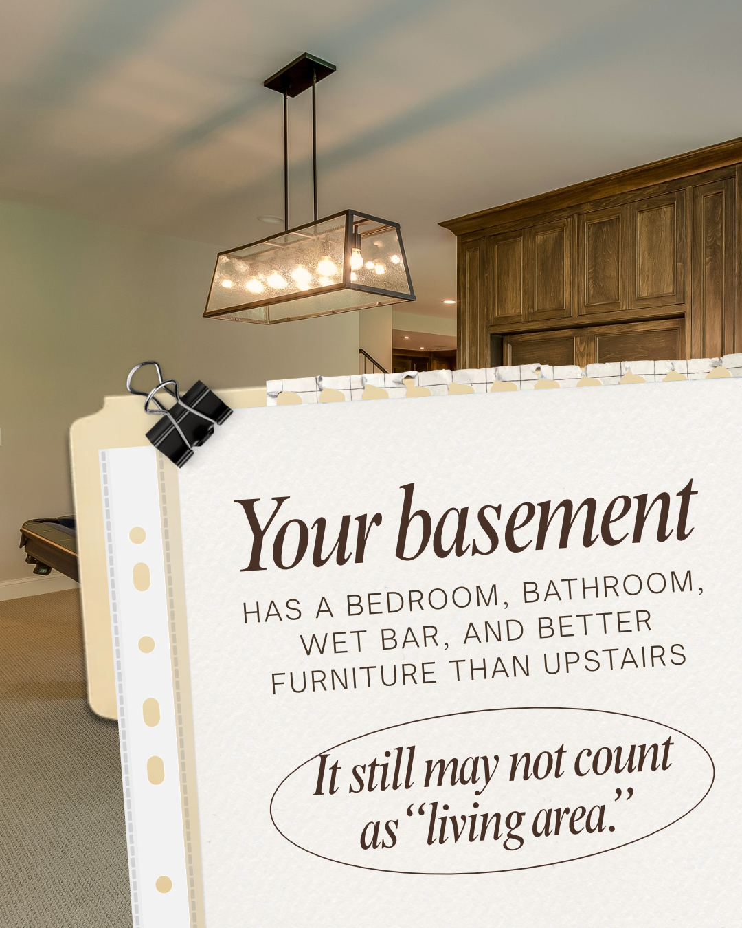 Finished basement with wood cabinetry and a paper graphic explaining that the space may not count as above-grade living area